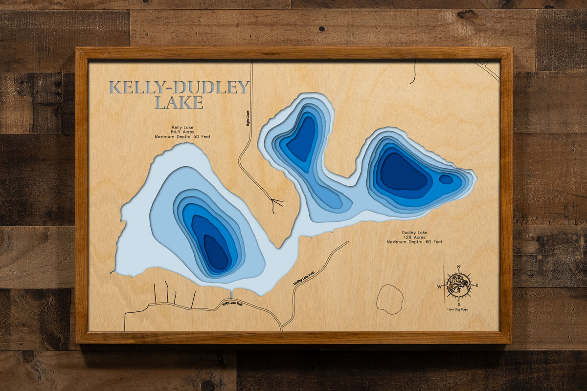 A precision laser-cut, multi-layered wooden map of Kelly-Dudley Lake in Rice County, Minnesota, the connected pair of Kelly and Dudley Lakes near Shieldsville rated among the healthiest lakes in the county. The natural wood top layer captures both shorelines in fine detail, while a light-to-dark blue gradient conveys depths reaching 60 feet. A handcrafted statement piece for any Minnesota lake home, cabin, or outdoor enthusiast's wall.