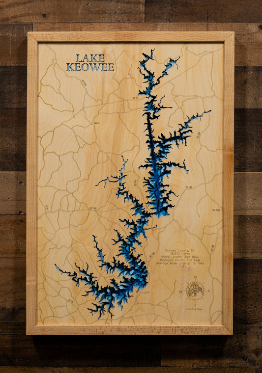 A meticulously detailed, laser-cut, multi-layered wooden map of Lake Keowee in Oconee County, South Carolina, showcasing the reservoir's distinctive Christmas tree shape with its main channel and numerous side coves, depth contours reaching 155 feet, the 71 islands scattered throughout, and the 300 miles of developed shoreline nestled in the Blue Ridge foothills.