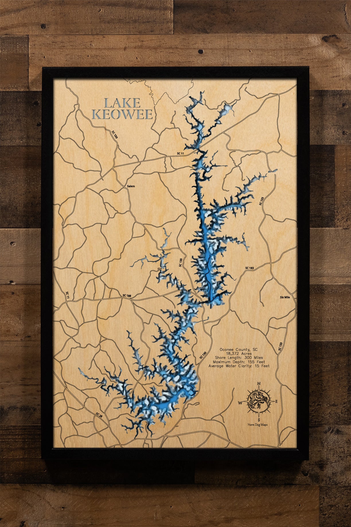 A meticulously detailed, laser-cut, multi-layered wooden map of Lake Keowee in Oconee County, South Carolina, showcasing the reservoir's distinctive Christmas tree shape with its main channel and numerous side coves, depth contours reaching 155 feet, the 71 islands scattered throughout, and the 300 miles of developed shoreline nestled in the Blue Ridge foothills.