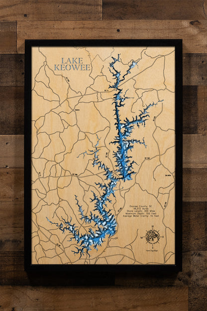 A meticulously detailed, laser-cut, multi-layered wooden map of Lake Keowee in Oconee County, South Carolina, showcasing the reservoir's distinctive Christmas tree shape with its main channel and numerous side coves, depth contours reaching 155 feet, the 71 islands scattered throughout, and the 300 miles of developed shoreline nestled in the Blue Ridge foothills.