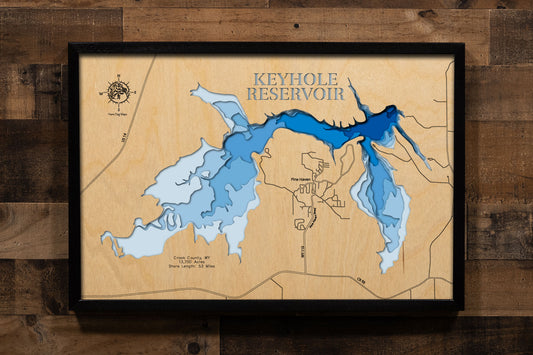 A precision laser-cut, multi-layered wooden map of Keyhole Reservoir in Crook County, Wyoming — a 13,700-acre Bureau of Reclamation reservoir on the Belle Fourche River near Moorcroft with 53 miles of dramatic shoreline. The natural wood top layer captures every rugged cove in fine detail, while a light-to-dark blue gradient conveys the reservoir's crystal-clear, wide-open character. A handcrafted statement piece for any Wyoming home, Black Hills retreat, or outdoor enthusiast's wall.