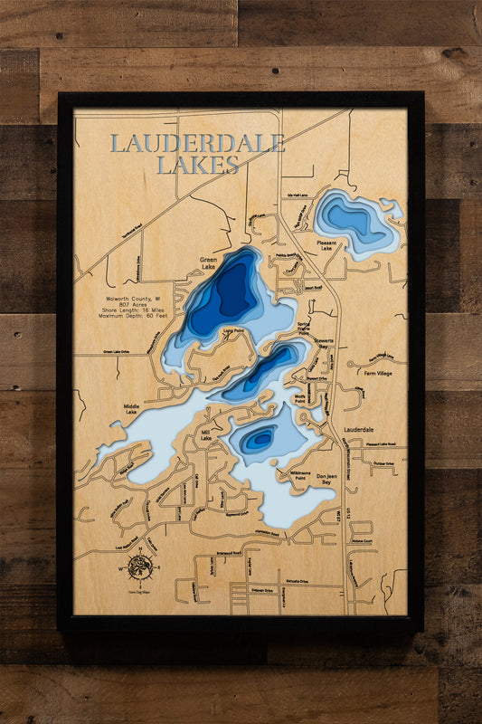 A beautifully crafted, multi-dimensional laser-cut wooden topographic map of Lauderdale Lakes in Walworth County, Wisconsin. The intricate design highlights the interconnected chain of Green Lake, Middle Lake, and Mill Lake spanning 807 acres, the numerous small islands scattered throughout, depth variations reaching 60 feet, and the winding 16 miles of scenic shoreline with detailed bays.