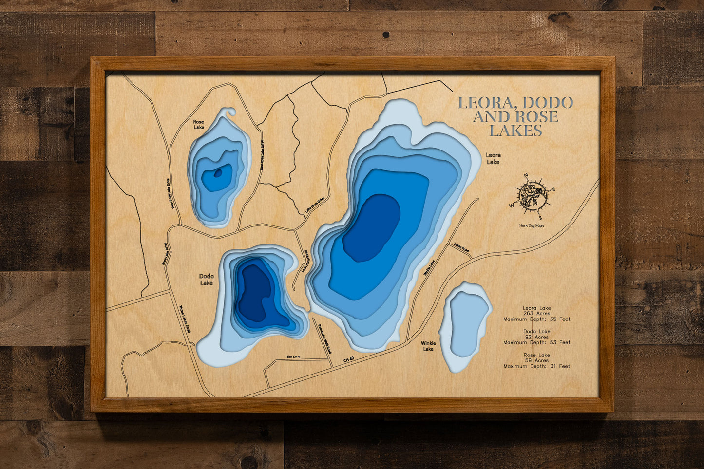 A precision laser-cut, multi-layered wooden map of Leora, Dodo, and Rose Lakes in St. Louis County, Minnesota — three pristine Northwoods lakes near Cotton east of Highway 53. The natural wood top layer captures the distinct shorelines of all three lakes in fine detail, while a light-to-dark blue gradient conveys depths ranging from 31 to 53 feet across the trio. A handcrafted statement piece for any Minnesota Northwoods cabin, lake home, or outdoor enthusiast's wall.
