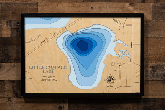 A precision laser-cut, multi-layered wooden map of Little Comfort Lake in Chisago County, Minnesota — a small, private lake of just 37 acres with a striking maximum depth of 56 feet. The natural wood top layer captures its intimate shoreline in fine detail, while a light-to-dark blue gradient conveys the lake's surprising depth. A handcrafted statement piece for any Minnesota lake home, cabin, or outdoor enthusiast's wall.