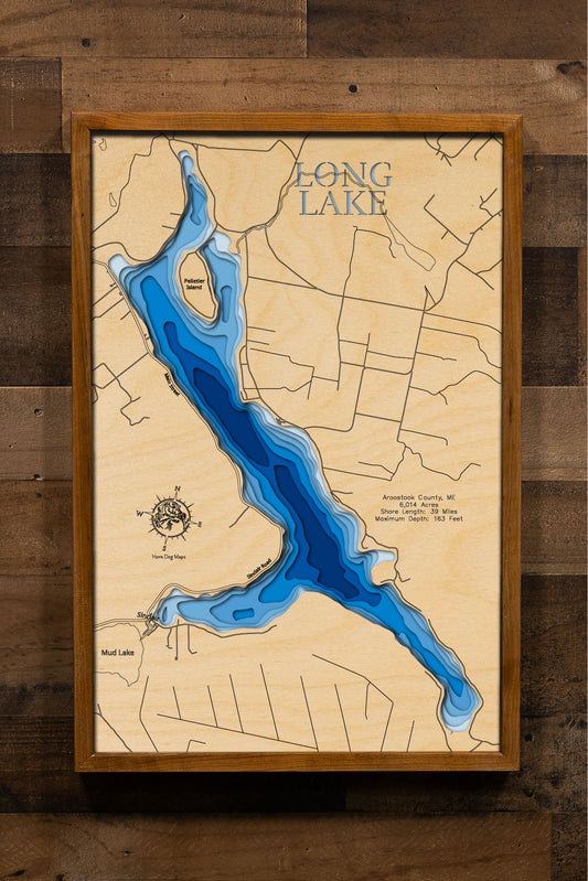 A laser-cut, layered wooden map of Long Lake in Aroostook County, Maine. The distinct elongated shape of this large natural lake, with its 39-mile shoreline, is clearly visible as it stretches through the northern Maine landscape. The varying depths of the lake, reaching a maximum of 163 feet, are represented by different layers of wood, illustrating its impressive underwater topography.