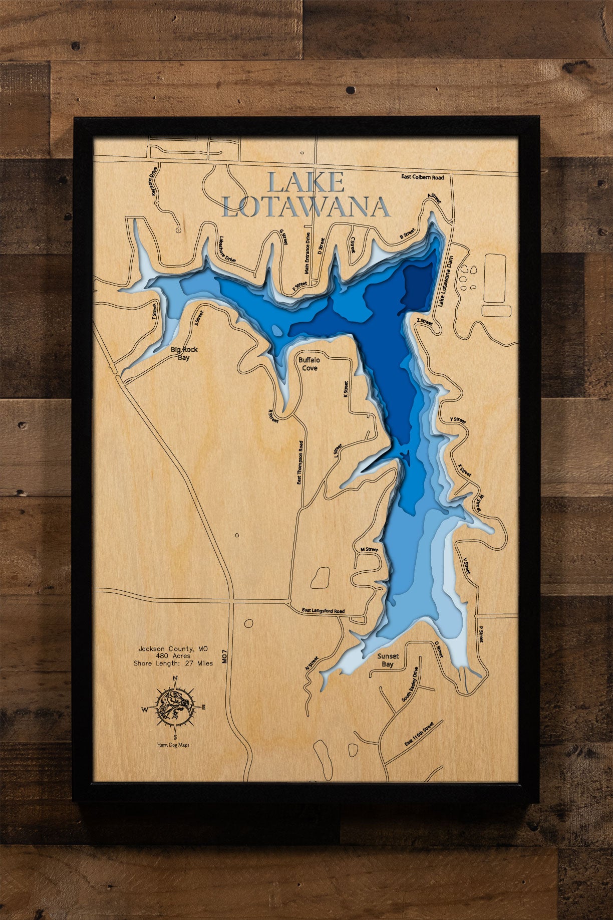 A precision laser-cut, multi-layered wooden map of Lake Lotawana in Jackson County, Missouri — the largest private lake in the Kansas City metro area, featuring 480 acres and 27 miles of cove-lined shoreline. The natural wood top layer captures every curve and cove of this storied private community lake in fine detail, while a light-to-dark blue gradient brings its sparkling waters to life. A handcrafted statement piece for any Missouri lake home, Kansas City retreat, or outdoor enthusiast's wall.