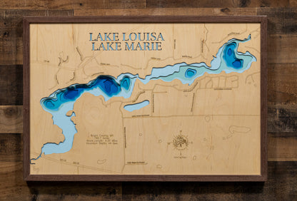 A beautifully crafted laser-cut wooden lake map of Lake Louisa in Wright County, Minnesota. The map features the lake's distinct shape and its connection to the surrounding landscape, with the water sections finished in a rich blue stain. Key statistics, such as the surface area and 44-foot maximum depth, are precisely etched into the wood, creating a unique and detailed piece of art that honors the geography of this beloved Wright County lake.