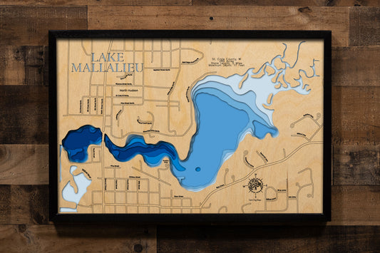 A precision laser-cut, multi-layered wooden map of Lake Mallalieu in St. Croix County, Wisconsin, a 289-acre Willow River flowage in North Hudson connected to the St. Croix River near the Minnesota border. The natural wood top layer captures 5 miles of natural shoreline in fine detail, while a light-to-dark blue gradient conveys the lake's shallow, river-connected character. A handcrafted statement piece for any Wisconsin lake home, Hudson-area cabin, or outdoor enthusiast's wall.