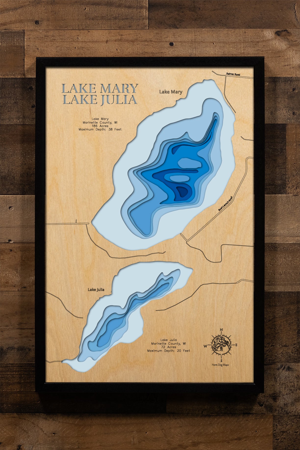 A precision laser-cut, multi-layered wooden map of Lake Mary in Marinette County, Wisconsin. The natural wood top layer captures the lake's clean, organic shoreline in fine detail, while a light-to-dark blue gradient highlights the water's depth and dimension. A distinctive, rustic statement piece crafted for cabin walls, fishing lodges, or any Wisconsin Northwoods-inspired living space.