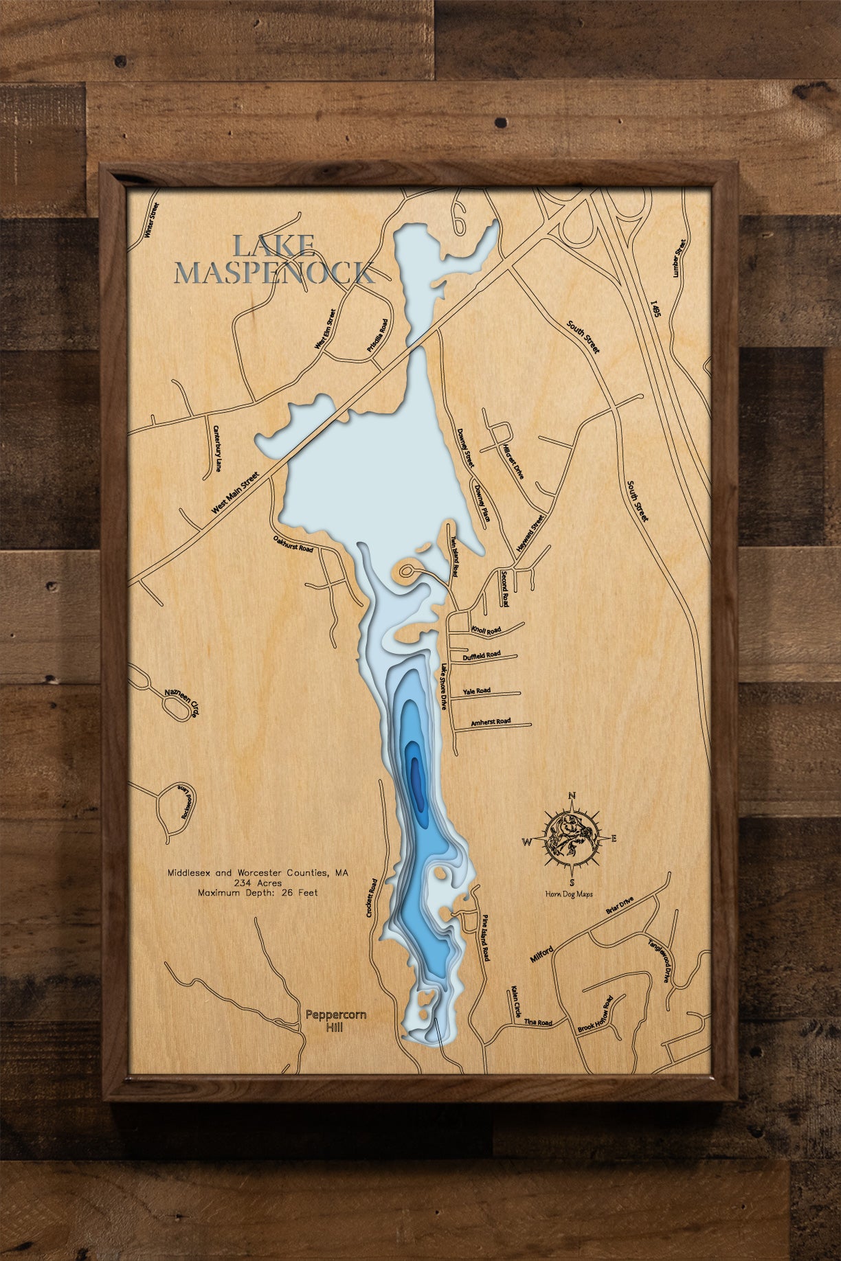 A meticulously detailed, laser-cut wooden topographic map of Lake Maspenock spanning Hopkinton in Middlesex County and Upton and Milford in Worcester Counties, Massachusetts. The multi-layered artwork showcases the lake's 234-acre surface, depth contours revealing the 26-foot maximum depth, the distinctive two-mile north-south orientation, and Sandy Island connected to shore.