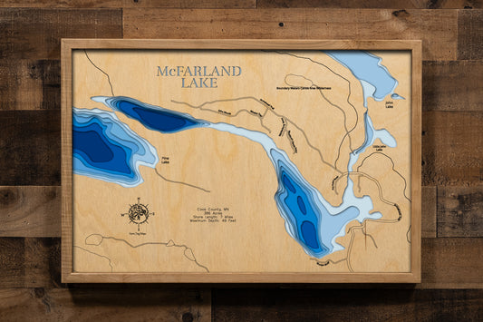 A precision laser-cut, multi-layered wooden map of McFarland Lake in Cook County, Minnesota, a Gunflint Trail gateway lake to the Boundary Waters. The natural wood top layer captures 7 miles of remote, forested shoreline in fine detail, while a light-to-dark blue gradient conveys the lake's 49-foot depth. A handcrafted statement piece for any BWCA basecamp, Northwoods cabin, or Gunflint Trail enthusiast's wall.
