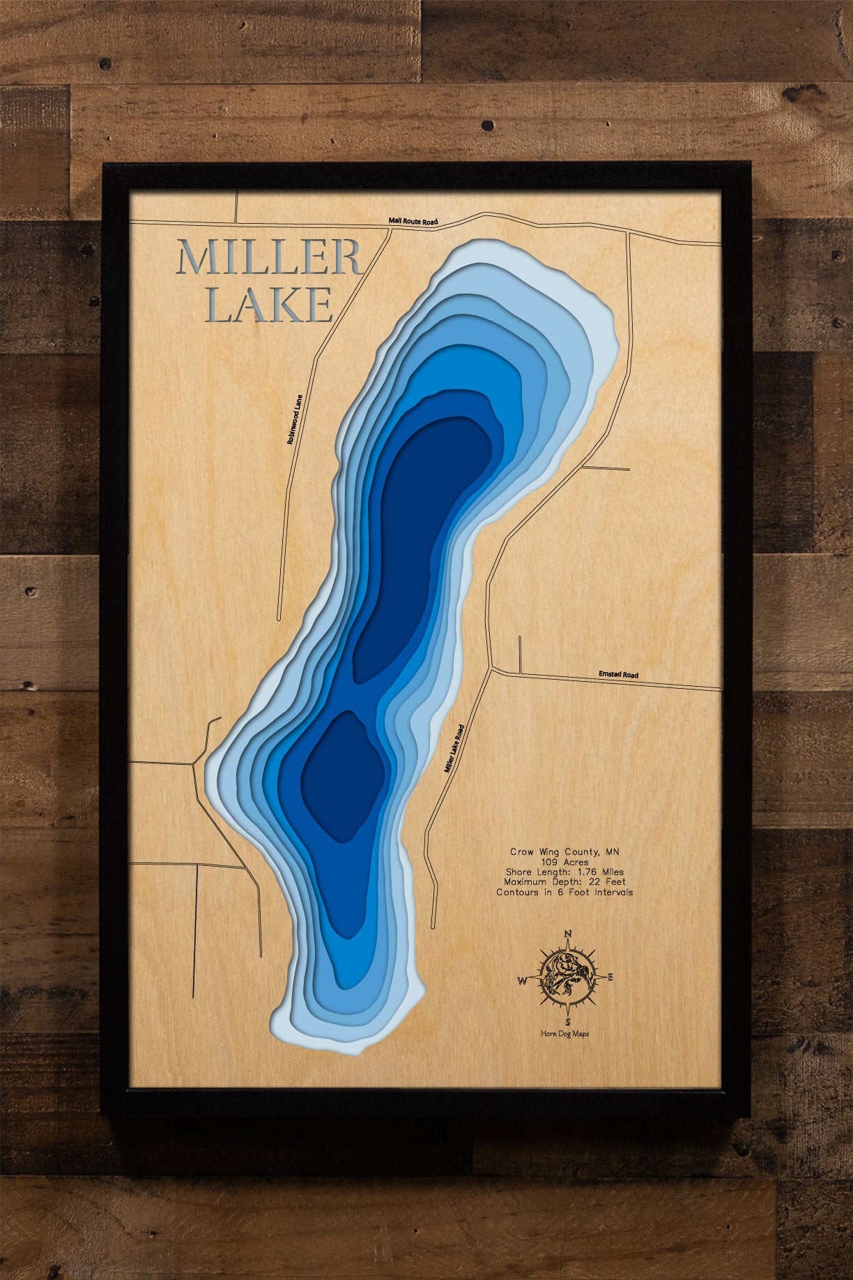 A laser-cut, layered wooden map of Miller Lake in Crow Wing County, Minnesota. The distinct shape of this natural lake, with its 1.76-mile shoreline, is clearly visible within the forested landscape of central Minnesota. The varying depths of the lake, reaching a maximum of 22 feet and detailed by 6-foot contour intervals, are represented by different layers of wood, illustrating its impressive underwater topography.