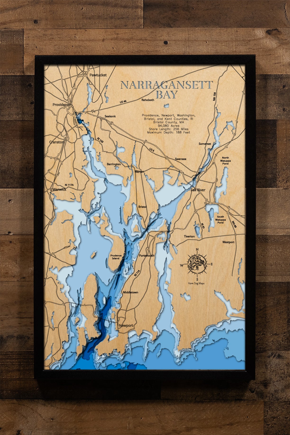 An expertly crafted laser-cut wooden map of Narragansett Bay, New England's largest estuary, showcasing the 147-square-mile bay spanning Rhode Island and Massachusetts, over 30 islands including Aquidneck, Conanicut, and Prudence, 256 miles of intricate shoreline, three distinct passages (West, East, and Sakonnet River), and layered depth contours revealing the 188-foot maximum depth.