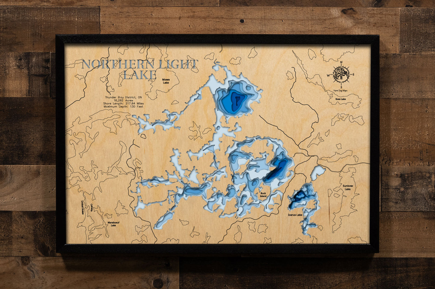 A precision laser-cut, multi-layered wooden map of Northern Light Lake in Thunder Bay District, Ontario, a 16,282-acre Canadian Shield wilderness lake near Atikokan with nearly 218 miles of dramatic shoreline and a maximum depth of 130 feet. The natural wood top layer captures every bay, island, and granite point in fine detail, while a light-to-dark blue gradient conveys the lake's remarkable depth. A handcrafted statement piece for any Ontario fishing camp, wilderness cabin, or Thunder Bay area enthusiast