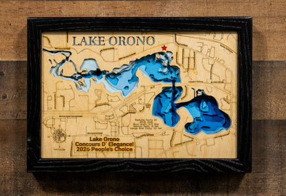 A framed wooden Lake Orono map wall art piece with blue recessed water features, a small red star marker, and engraved text, displayed against a rustic wood plank background.