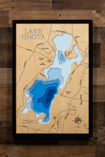 A precision laser-cut, multi-layered wooden map of Lake Onota in Berkshire County, Massachusetts — a 617-acre great pond in Pittsfield with two distinct basins and a maximum depth of 72 feet. The natural wood top layer captures the lake's varied shoreline in fine detail, while a light-to-dark blue gradient conveys its striking depth. A handcrafted statement piece for any Berkshires home, New England cabin, or outdoor enthusiast's wall.