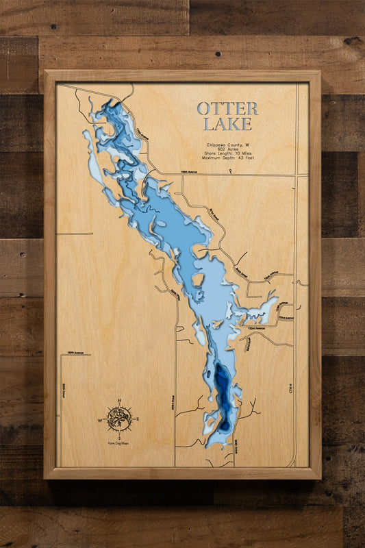 A meticulously detailed, laser-cut, multi-layered wooden topographical map of Otter Lake in Chippewa County, Wisconsin, showcasing the 602-acre reservoir created in 1969 with depth contours from the 11-foot average to the 43-foot maximum depth. The natural wood top layer frames approximately 10 miles of shoreline including the historic dam, Otter Lake County Park with 22 campsites, four public boat launches, and two aeration systems, while graduated blue layers create a striking visual depth gradient across