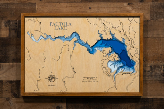 A spectacular multi-layered, laser-cut wooden topographic map of Pactola Lake in Pennington County, South Dakota. The intricate design captures the reservoir's impressive 823-acre expanse with depth contours plunging to the remarkable 150-foot maximum depth, the five-mile length with 16 miles of shoreline, Pactola Dam at the eastern end, and the dramatic Black Hills National Forest terrain surrounding this jewel of the Black Hills.