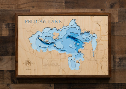 A laser-cut, layered wooden map of Pelican Lake in St. Louis County, Minnesota. The distinct shape of this large lake, with its 55.71-mile shoreline and numerous islands, is clearly visible within the forested landscape of northern Minnesota near the town of Orr. The varying depths of the lake, reaching a maximum of 40 feet, are represented by different layers of wood, illustrating its impressive underwater topography.