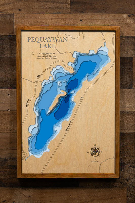 A laser-cut, layered wooden map of Pequaywan Lake in St. Louis County, Minnesota. The distinct shape of this natural lake, with its 6.49-mile shoreline, is clearly visible within the forested landscape of northeastern Minnesota. The varying depths of the lake, reaching a maximum of 33 feet, are represented by different layers of wood, illustrating its impressive underwater topography.