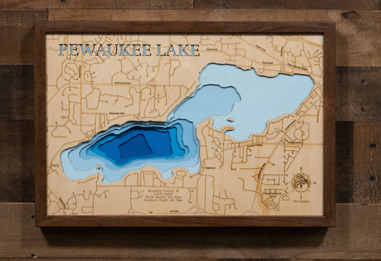 Laser-engraved relief map of Pewaukee Lake in Waukesha County, WI, crafted from wood with high precision.