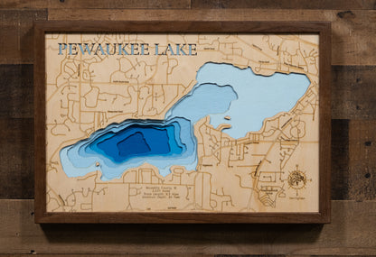 Laser-engraved relief map of Pewaukee Lake in Waukesha County, WI, crafted from wood with high precision.