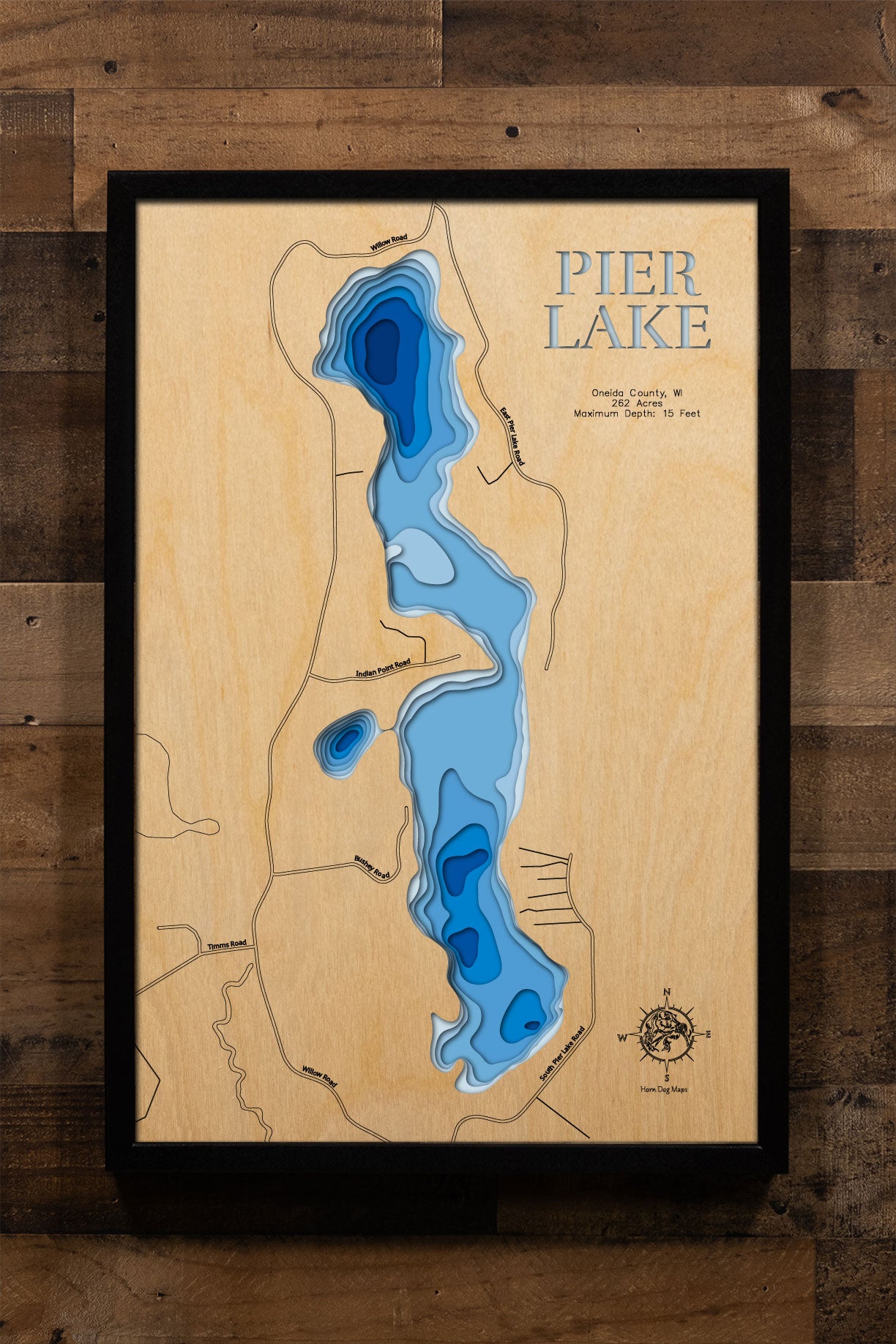 A precision laser-cut, multi-layered wooden map of Pier Lake in Oneida County, Wisconsin, a 262-acre warmwater lake near Minocqua holding Bass, Pike, Walleye, and Panfish. The natural wood top layer captures the lake's natural shoreline in fine detail, while a light-to-dark blue gradient conveys its shallow, productive character. A handcrafted statement piece for any Wisconsin Northwoods cabin, lake home, or outdoor enthusiast's wall.