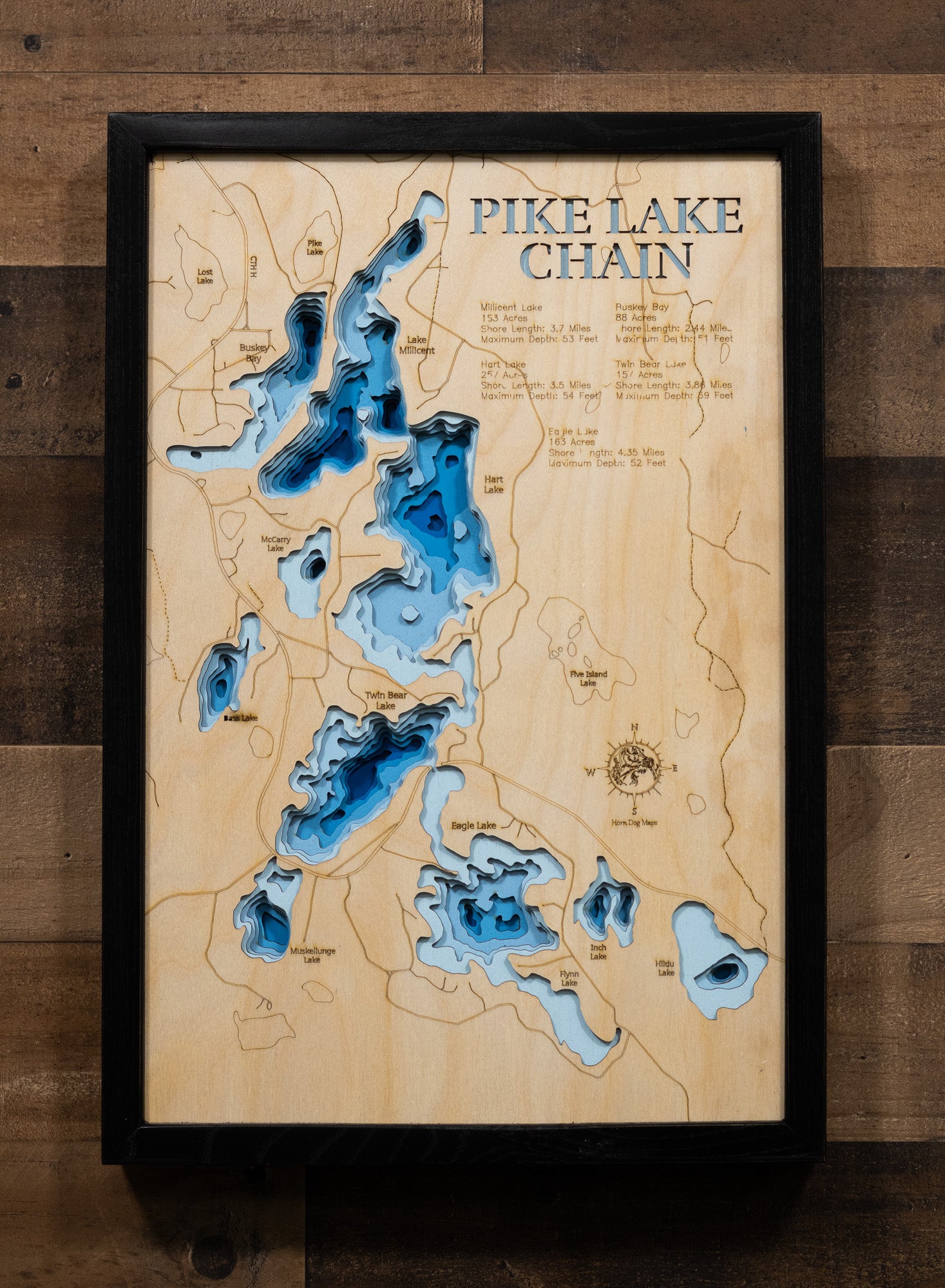 A highly detailed, laser-cut, and multi-layered wooden map of the Pike Chain of Lakes in Bayfield County, Wisconsin. The map shows the distinct shapes of Upper, Middle, and Lower Pike Lakes and their extensive, interconnected shoreline of 25.26 miles. The varying depths of the chain, reaching a maximum of 53 feet, are represented by different layers of wood.