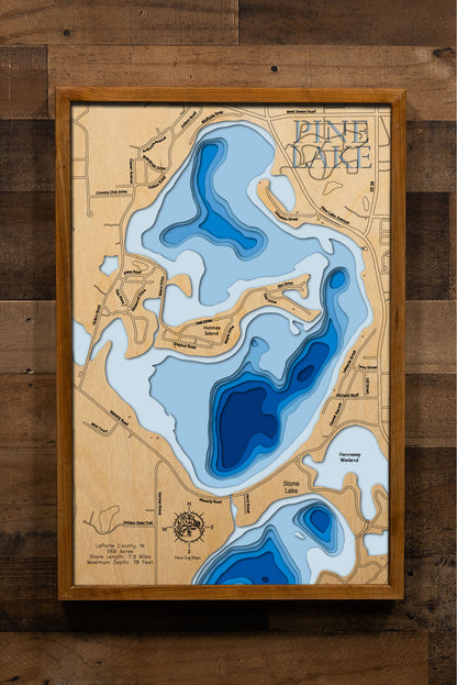 A highly detailed, laser-cut, and multi-layered wooden map of Pine Lake, a natural lake in LaPorte County, Indiana. The map shows the lake's distinct shape and its 7.9-mile shoreline. The varying depths of the lake, reaching a maximum of 78 feet, are represented by different layers of wood.