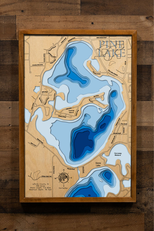 A highly detailed, laser-cut, and multi-layered wooden map of Pine Lake, a natural lake in LaPorte County, Indiana. The map shows the lake's distinct shape and its 7.9-mile shoreline. The varying depths of the lake, reaching a maximum of 78 feet, are represented by different layers of wood.