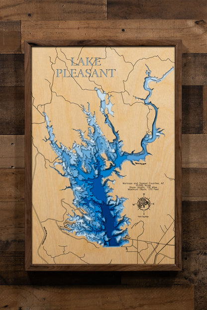 A precision laser-cut, multi-layered wooden map of Lake Pleasant in Maricopa and Yavapai Counties, Arizona — a 10,000-acre Sonoran Desert reservoir northwest of Phoenix with 116 miles of dramatic canyon shoreline. The natural wood top layer captures every rugged cove in fine detail, while a light-to-dark blue gradient conveys the lake's 170-foot depth. A handcrafted statement piece for any Arizona lake home, desert retreat, or outdoor enthusiast's wall.