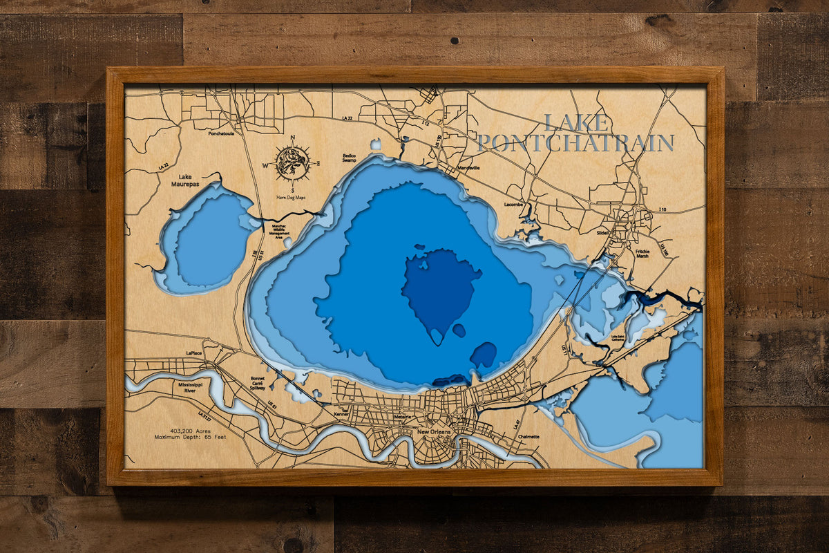 A precision laser-cut, multi-layered wooden map of Lake Pontchartrain in southeastern Louisiana, a 403,200-acre brackish estuary spanning six parishes near New Orleans crossed by the world's longest bridge over water. The natural wood top layer captures the lake's dramatic oval form in fine detail, while a light-to-dark blue gradient conveys its broad, shallow character. A handcrafted statement piece for any Louisiana lake home, New Orleans retreat, or Gulf Coast enthusiast's wall.