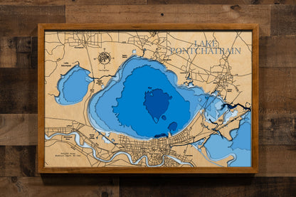 A precision laser-cut, multi-layered wooden map of Lake Pontchartrain in southeastern Louisiana, a 403,200-acre brackish estuary spanning six parishes near New Orleans crossed by the world's longest bridge over water. The natural wood top layer captures the lake's dramatic oval form in fine detail, while a light-to-dark blue gradient conveys its broad, shallow character. A handcrafted statement piece for any Louisiana lake home, New Orleans retreat, or Gulf Coast enthusiast's wall.