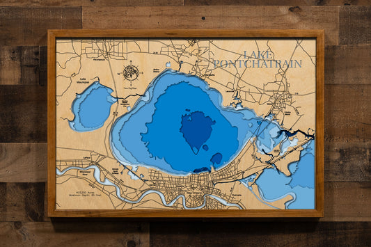 A precision laser-cut, multi-layered wooden map of Lake Pontchartrain in southeastern Louisiana, a 403,200-acre brackish estuary spanning six parishes near New Orleans crossed by the world's longest bridge over water. The natural wood top layer captures the lake's dramatic oval form in fine detail, while a light-to-dark blue gradient conveys its broad, shallow character. A handcrafted statement piece for any Louisiana lake home, New Orleans retreat, or Gulf Coast enthusiast's wall.