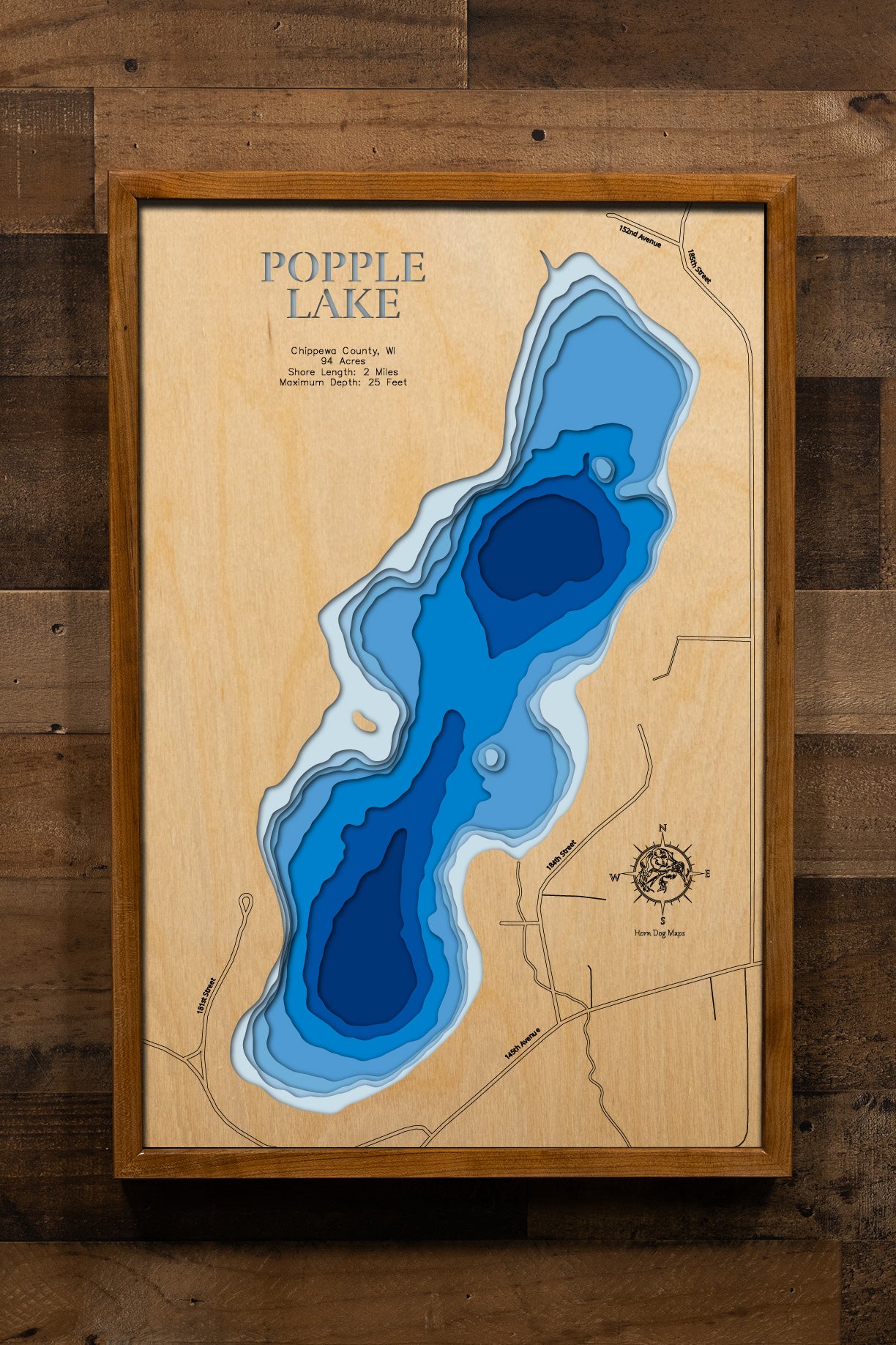 A meticulously detailed, laser-cut, multi-layered wooden topographical map of Popple Lake in Chippewa County, Wisconsin, showcasing the intimate 94-acre lake with lily pad beds and depth contours from sandy shallows to the 25-foot maximum depth. The natural wood top layer frames approximately two miles of peaceful shoreline with the public boat landing near Jim Falls, while graduated blue layers create a gentle visual depth gradient across this tranquil fishing lake.