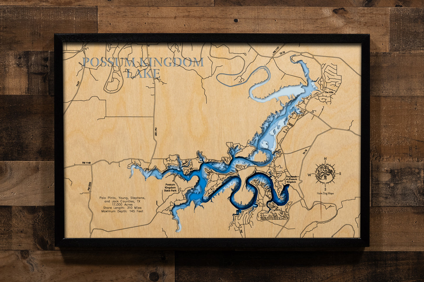 An exquisitely detailed, multi-layered laser-cut wooden topographic map of Possum Kingdom Lake winding through the Palo Pinto Mountains across four Texas counties, featuring depth contours illustrating the dramatic 145-foot maximum depth, the serpentine 310-mile shoreline carved through limestone canyons, the iconic Hell's Gate formation with its towering cliffs, Morris Sheppard Dam at the southern terminus, and the 65-mile stretch of pristine blue water following the ancient Brazos River channel.