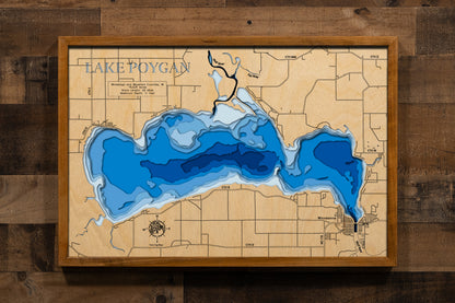 A precision laser-cut, multi-layered wooden map of Lake Poygan spanning Winnebago and Waushara Counties, Wisconsin. The natural wood top layer captures 25 miles of shoreline and the lake's sweeping, shallow basin in fine detail, while a light-to-dark blue gradient highlights the water's depth and dimension. A stunning, rustic statement piece for any Wisconsin lake home, fishing lodge, or sports room.