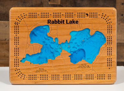 A laser-cut, layered wooden map of Rabbit Lake in Crow Wing County, Minnesota. The distinct shapes of the two interconnected basins and their shared shoreline of 11.81 miles are clearly visible within the forested landscape of central Minnesota. The varying depths of the lake, reaching a remarkable maximum of 337 feet in the eastern basin, are represented by different layers of wood, illustrating its impressive and dramatic underwater topography.