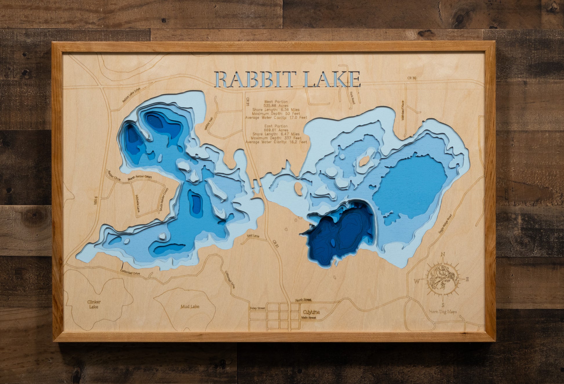 A laser-cut, layered wooden map of Rabbit Lake in Crow Wing County, Minnesota. The distinct shapes of the two interconnected basins and their shared shoreline of 11.81 miles are clearly visible within the forested landscape of central Minnesota. The varying depths of the lake, reaching a remarkable maximum of 337 feet in the eastern basin, are represented by different layers of wood, illustrating its impressive and dramatic underwater topography.