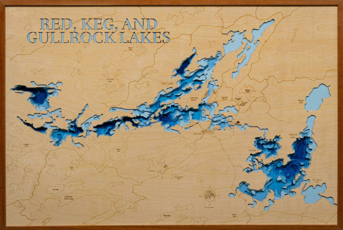A 3D wooden map of Red, Keg, and Gullrock Lakes, featuring layered blue wood cutouts representing the lake depths over a light natural wood background, enclosed in a dark wood frame.