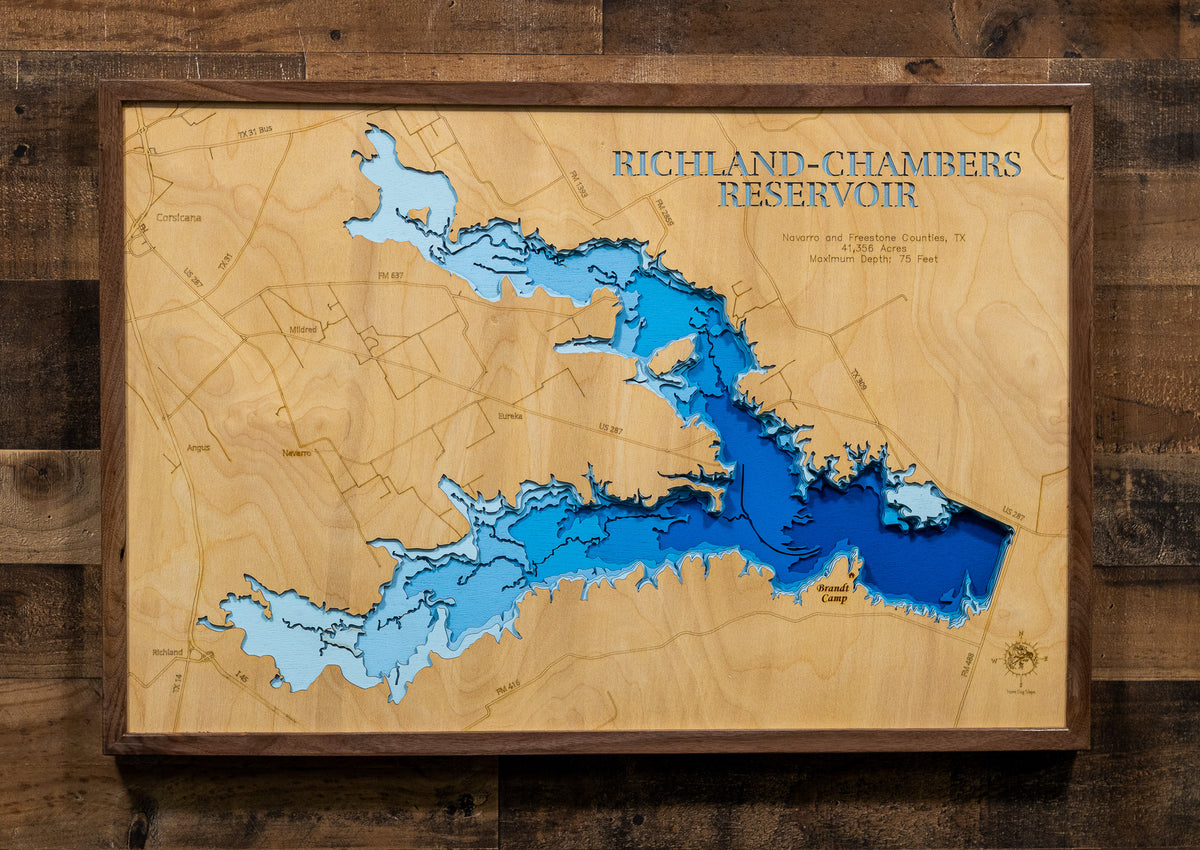 A framed wooden map of Richland-Chambers Reservoir, featuring layered blue water levels and topographic contour lines on a light wood background, mounted on a dark wood plank wall.
