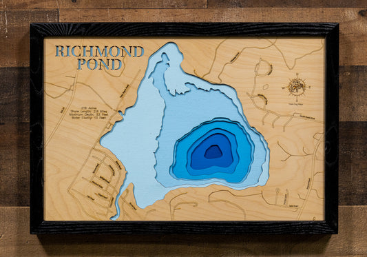 A framed wooden pond depth map of Richmond Pond, featuring layered blue water cutouts over a light wood background, mounted on a dark wood wall.