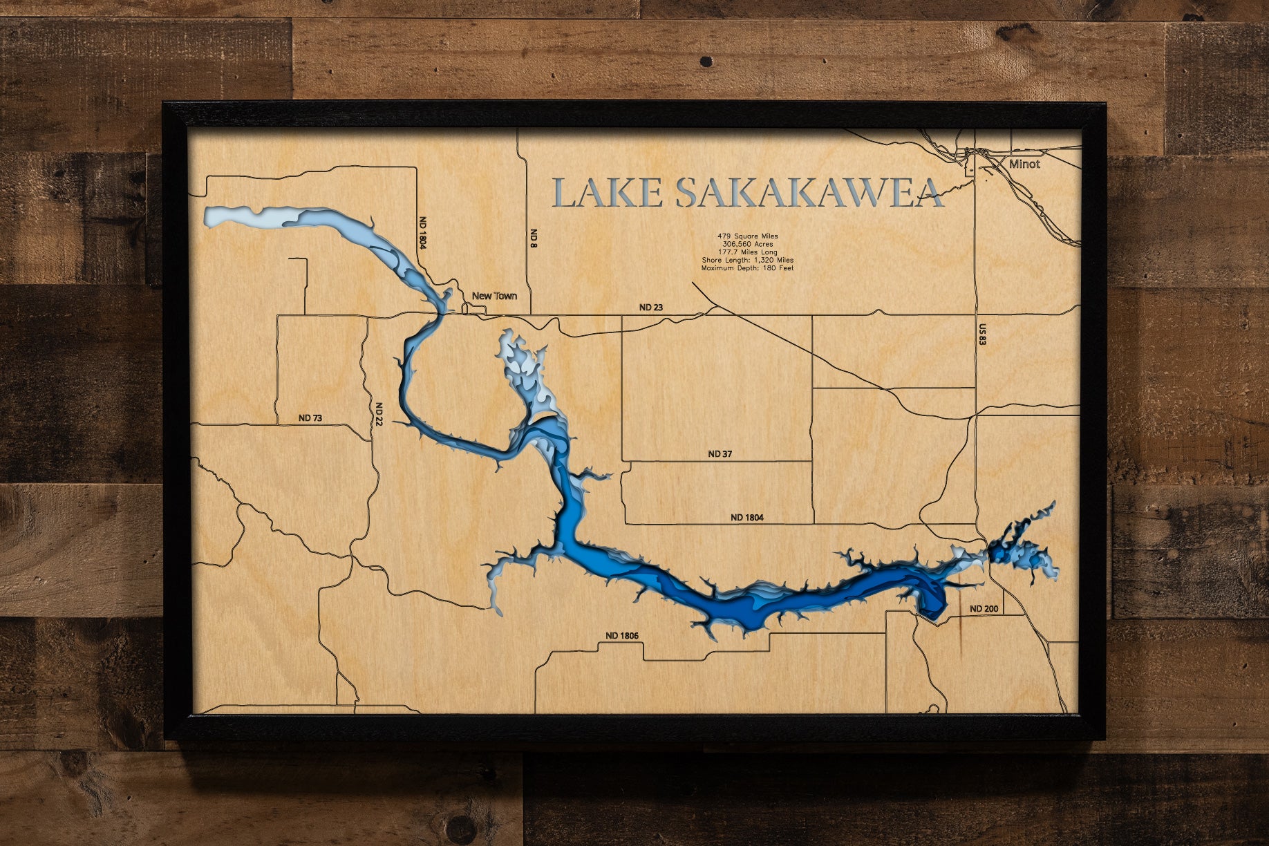 A highly detailed, laser-cut, and multi-layered wooden map of Lake Sakakawea stretching across six North Dakota counties. The map showcases the reservoir's impressive 178-mile length along the Missouri River, with depth contours highlighting the 180-foot maximum depth, the expansive Van Hook Arm, and the 1,320 miles of intricate shoreline detail.