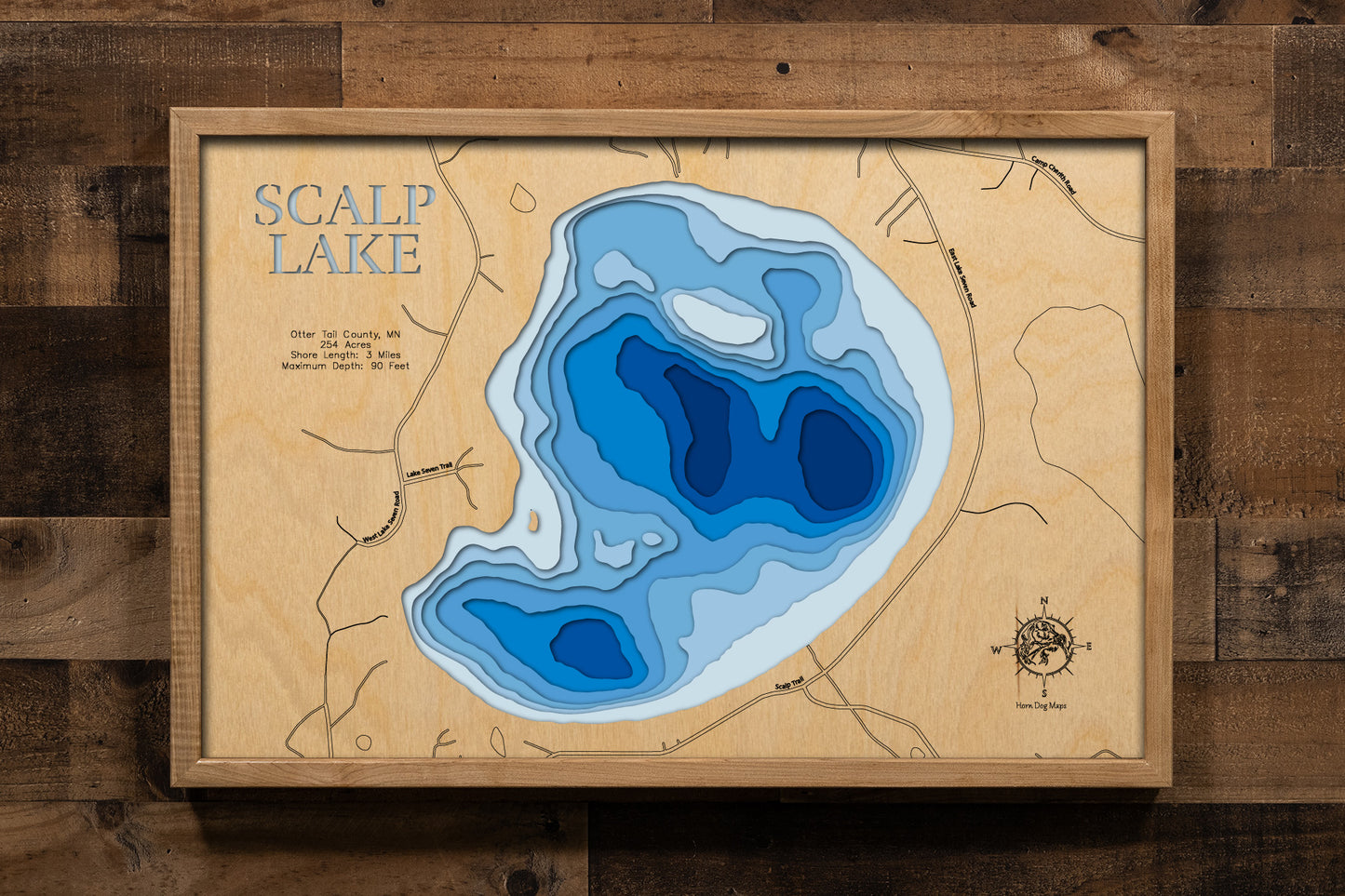 A meticulously detailed, laser-cut, multi-layered wooden topographical map of Scalp Lake in Otter Tail County, Minnesota, showcasing the 254-acre lake's surface with dramatic depth contours illustrating the transition from shallower areas to the impressive 90-foot maximum depth. The natural wood top layer frames three miles of shoreline with the public boat launch, while graduated blue layers create a striking visual depth gradient.