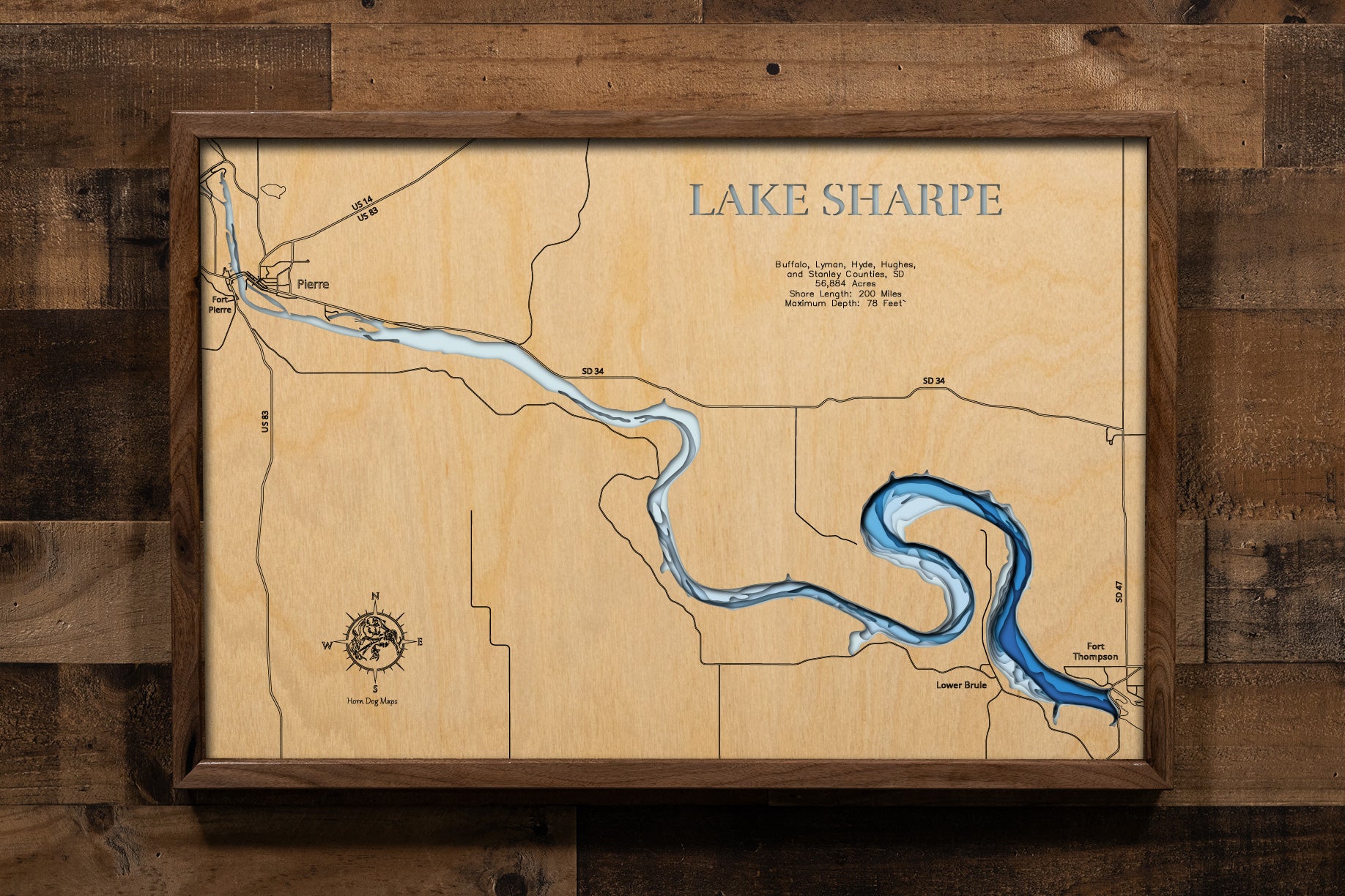 A stunning multi-layered, laser-cut wooden topographic map of Lake Sharpe stretching through Buffalo, Lyman, Hyde, Hughes, and Stanley Counties in central South Dakota. The intricate design captures the reservoir's serpentine 80-mile course from Big Bend Dam to Oahe Dam, depth contours showing the 78-foot maximum depth, the dramatic Big Bend horseshoe meander, and 200 miles of shoreline along the mighty Missouri River.