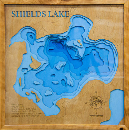 Laser-engraved relief map of Shields Lake in Rice County, MN, crafted from wood with high precision.