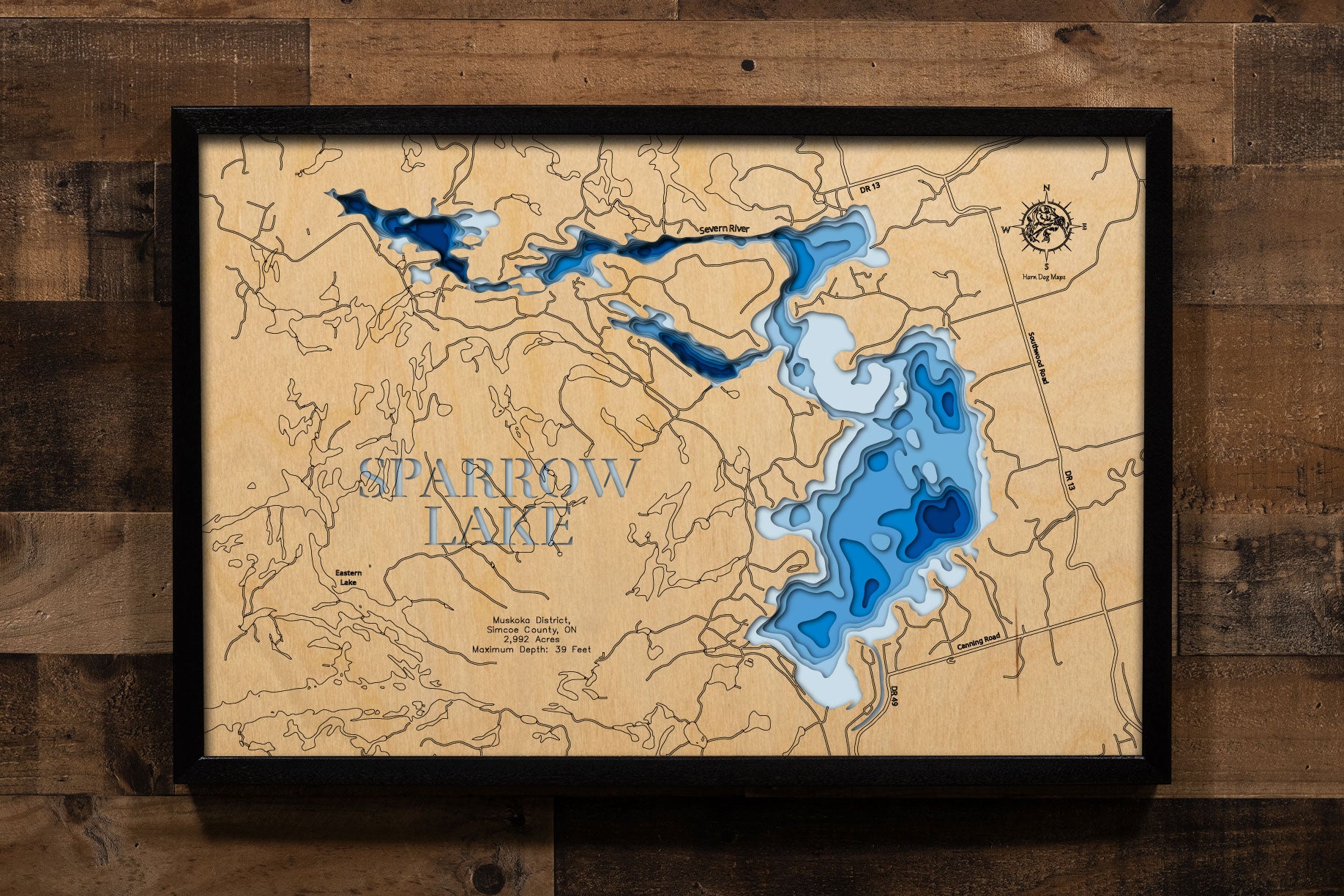 A precision laser-cut, multi-layered wooden map of Sparrow Lake in Muskoka District and Simcoe County, Ontario, a 2,992-acre Trent-Severn Waterway lake and the most southerly lake in Muskoka cottage country. The natural wood top layer captures every granite island and rocky cove in fine detail, while a light-to-dark blue gradient conveys the lake's 39-foot depth. A handcrafted statement piece for any Ontario cottage, Muskoka retreat, or Canadian Shield enthusiast's wall.
