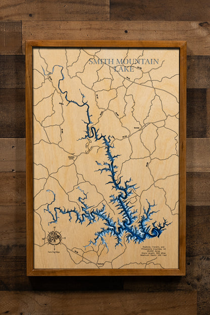 A breathtakingly detailed, laser-cut, multi-layered wooden map of Smith Mountain Lake spanning Bedford, Franklin, and Pittsylvania Counties, Virginia, showcasing the 20,600-acre reservoir's distinctive 40-mile serpentine course with 500 miles of intricate shoreline. Natural wood layers highlight the Hales Ford Bridge and surrounding Blue Ridge landscape, while graduated blue water layers illustrate depths to 250 feet.