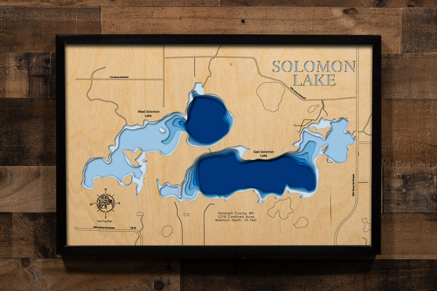 A precision laser-cut, multi-layered wooden map of East and West Solomon Lakes in Kandiyohi County, Minnesota — a connected pair of shallow prairie lakes covering 1,276 combined acres just northwest of Willmar. The natural wood top layer captures both lakes' shorelines and connecting channel in fine detail, while a light-to-dark blue gradient conveys their broad, productive character. A handcrafted statement piece for any Minnesota lake home, cabin, or outdoor enthusiast's wall.