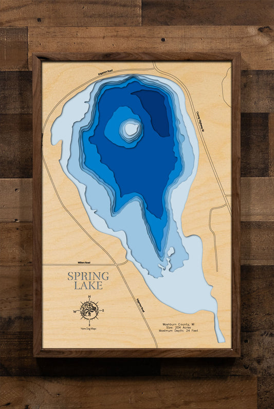 A laser-cut, layered wooden map of Spring Lake in Washburn County, Wisconsin. The distinct shape of the lake's shoreline is clearly defined within the Washburn County landscape. The varying depths of the lake, reaching a maximum of 24 feet, are represented by different layers of wood, creating a three-dimensional effect.